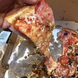 A really crappy piece of Mama's large combination pizza.  Toppings immediately fall off the pizza.