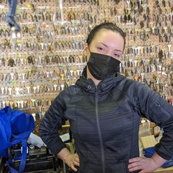 Ace Lock & Key Smith - Erika stands in front of a wall of keys at the shop, she ready to schedule your services, and copy your keys.