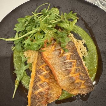 Aboyer - Loup de mer (branzino) over couscous with herb sauce and arugula - French Near Me - Winnetka, Illinois