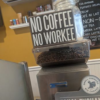 The Good Bean - Signage win. Very extensive menu with reasonable prices for a cute coffee shop like this!  Fresh coffee, free wi-fi, and kind service! - A coffee shop scene featuring a sign that says 'No Coffee No Workee,' a jar of sugar, and a coffee bean grinder, with a menu board in the background. - Coffee & Tea Near Me - Dover, New Jersey