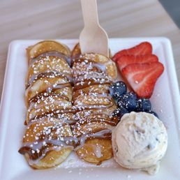 Mini pancakes with Nutella, lechera, strawberries, blue berries, & a scoop of mint chocolate chip ice cream.
