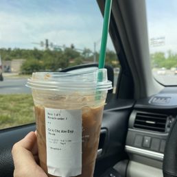 a hand holding a cup of iced coffee