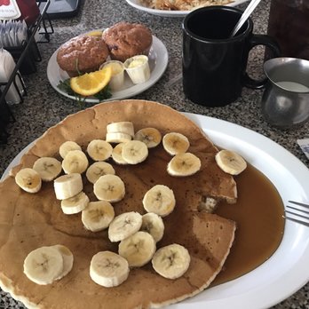 Morning Thunder Cafe - Single pancake with bananas on top and real maple syrup. In the back is two homemade cherry muffins. - Breakfast & Brunch Near Me - Chico, California Morning Thunder Cafe - Single pancake with bananas on top and real maple syrup. In the back is two homemade cherry muffins. - Breakfast & Brunch Near Me - Chico, California