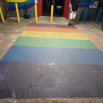 Barcode - a man standing in front of a rainbow painted parking garage - Bars Near Me - Houston, Texas