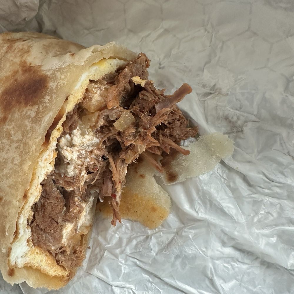 Red beef breakfast burrito with hash browns and sour cream Red beef breakfast burrito with hash browns and sour cream