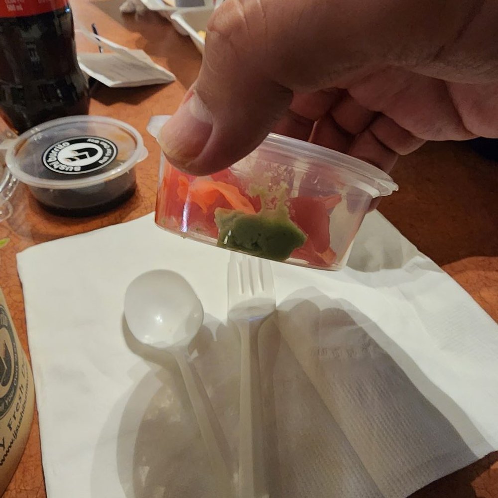 Ginger with a tiny thing of wasabi. Soy sauce in similar packaging to the left on the table. Ginger with a tiny thing of wasabi. Soy sauce in similar packaging to the left on the table.