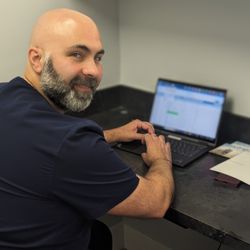 APICO Pain Management - Dr. Abdallah working in his office on charts.