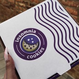 a hand holding a box of cookies a hand holding a box of cookies