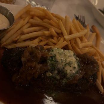 Petit Pomeroy - Steak A La Bordelaise - A meal featuring French fries, a steak topped with sauce and garnishes, served with a side of dipping sauce, on a restaurant table. - French Near Me - Chicago, Illinois