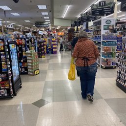 a woman walking down a grocery aisle a woman walking down a grocery aisle