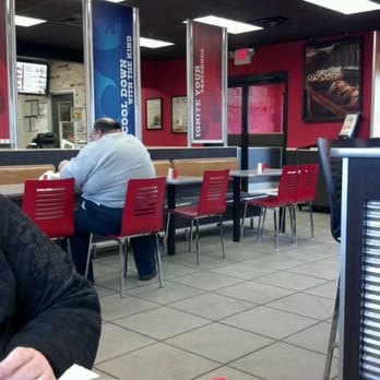 Burger King - a man sitting at a table in a restaurant - Burgers Near Me - Central Square, New York