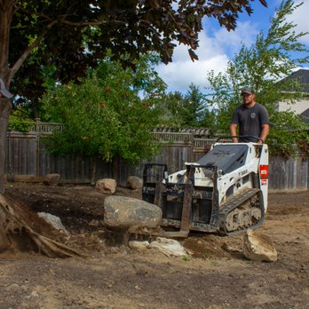 Precision Grounds Landscaping & Contracting - two men working on a tree stump - Landscape Architects or Designers Near Me