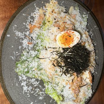 Shiso - Salad - A salad served on a dark plate includes shredded cheese, chopped lettuce, shredded seaweed, and a halved soft-boiled egg with seasoning. - Cocktail Bars Near Me - Miami, Florida