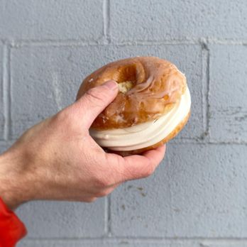 Camp Creemee - a person holding a donut with frosting - Ice Cream & Frozen Yogurt Near Me - Duluth, Minnesota