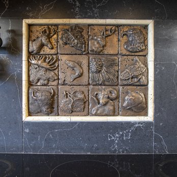 Rock Solid Creations - a stone wall with a relief of animals - Flooring Near Me - Groveland, California