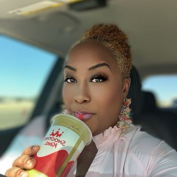 Smoothie King - a woman drinking a smoothie in a car - Juice Bars & Smoothies Near Me - Austin, Texas
