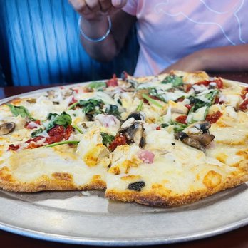 Hot Stone - a pizza sitting on a plate on a table - Pizza Near Me - Wynne, Arkansas