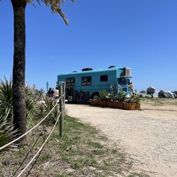 a blue bus parked on a dirt road