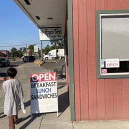 a woman standing in front of a restaurant a woman standing in front of a restaurant