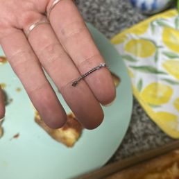 a person's hand holding a slice of pizza