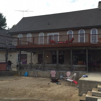 Bear Cave Lake - Fire pit on a little beach in front of the covered outdoor patio with bar and lots of seating. - Venues & Event Spaces Near Me - Oswego, Illinois