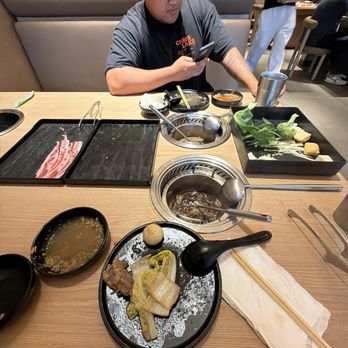 Mumu Hot Pot - Soup bowl/warmer is located at the middle of the table. I was not leaning over it, so I don't think the hair in my food came from me - Hot Pot Near Me - Torrance, California
