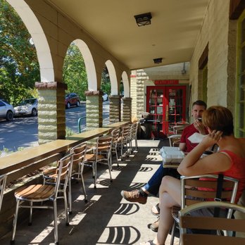 Dobrá Tea - a woman sitting on a bench and talking on a cell phone - Bakeries Near Me - Ashland, Oregon