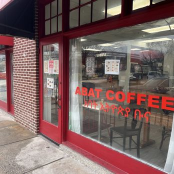 Abat Coffee - Abat Coffee's storefront features large glass windows with red framing, displaying the business name in bold red letters. - Coffee & Tea Near Me - Dundalk, Maryland