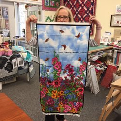 The Quilt Shop by Lois - An example of a beautiful panel available at the shop, held by Cookie.