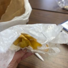 a person holding a sandwich in a wrapper