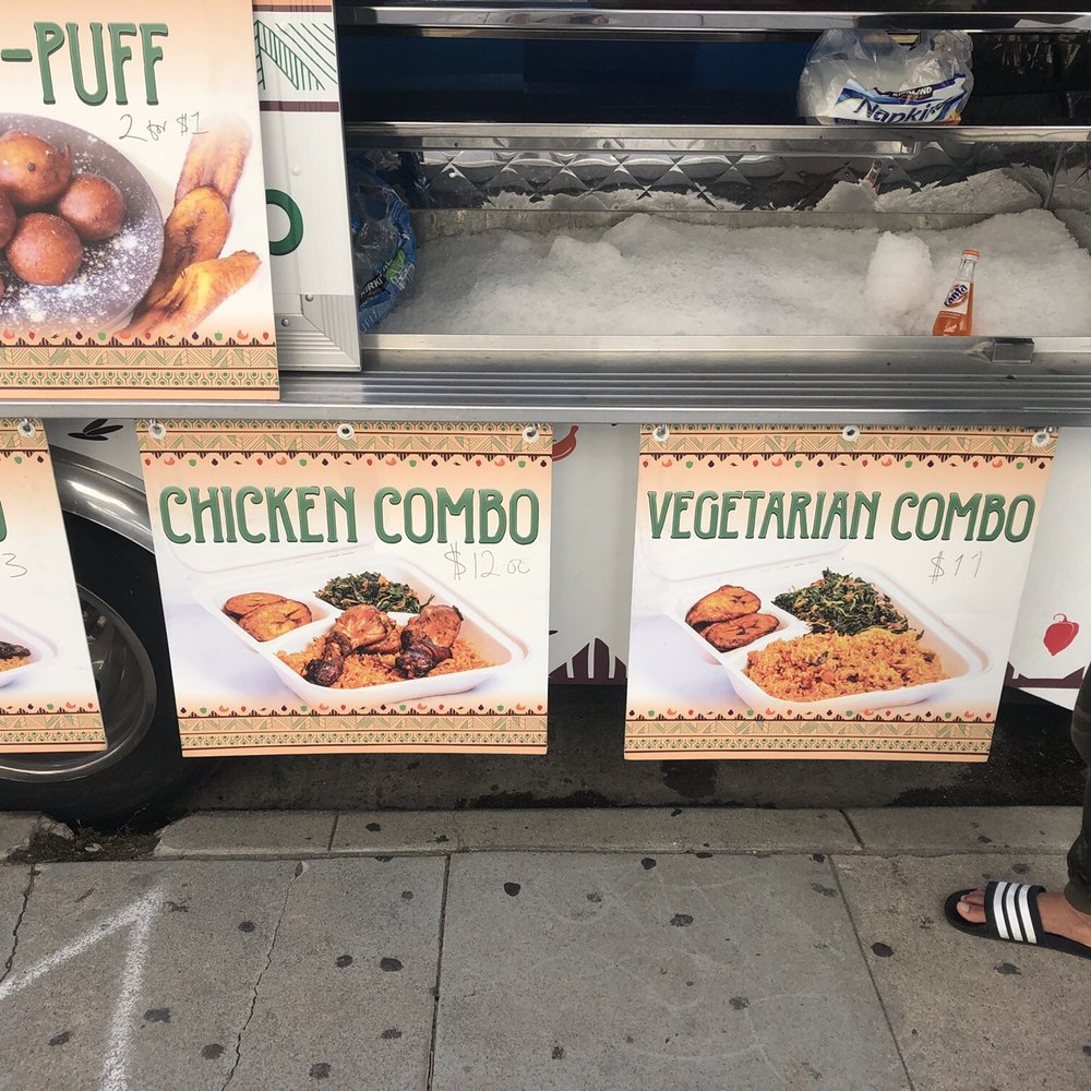 African Chop - a man standing in front of a food cart - Food Trucks Near Me