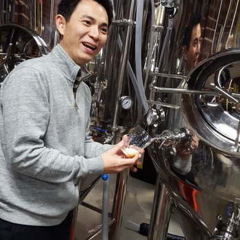 Hopstix - Andy Tan the owner pouring beer from one of the vats - Breweries Near Me - Chamblee, Georgia