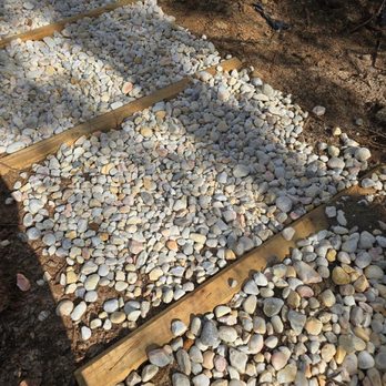 Precision Lawn and Land Services - Landscape timbers and river rock on a slope. - Landscaping Near Me