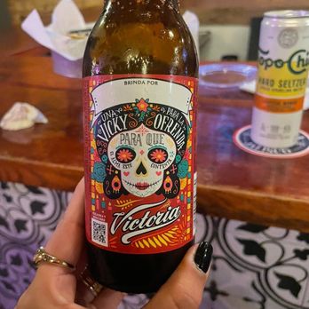 Cantina La Campana - a person holding a bottle of beer - Bars Near Me - Weslaco, Texas