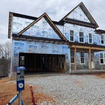 Harmony Home Inspection Services - Front exterior of a new home under construction wrapped in DRYline TSX weather barrier with exposed framing, windows, and a t... - Home Inspectors Near Me Harmony Home Inspection Services - Front exterior of a new home under construction wrapped in DRYline TSX weather barrier with exposed framing, windows, and a t... - Home Inspectors Near Me