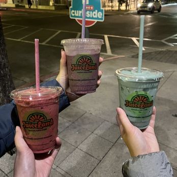 JuiceLand - two people holding up their drinks - Juice Bars & Smoothies Near Me - Austin, Texas