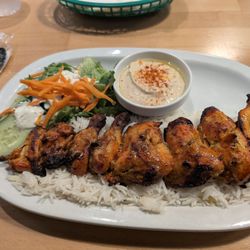 Cornish Game hen kabob plate with salad, rice, hummus and pita