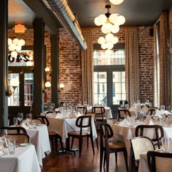 The Italian Barrel - Exposed brick, white tablecloths, and warm lighting in our French Quarter dining room.