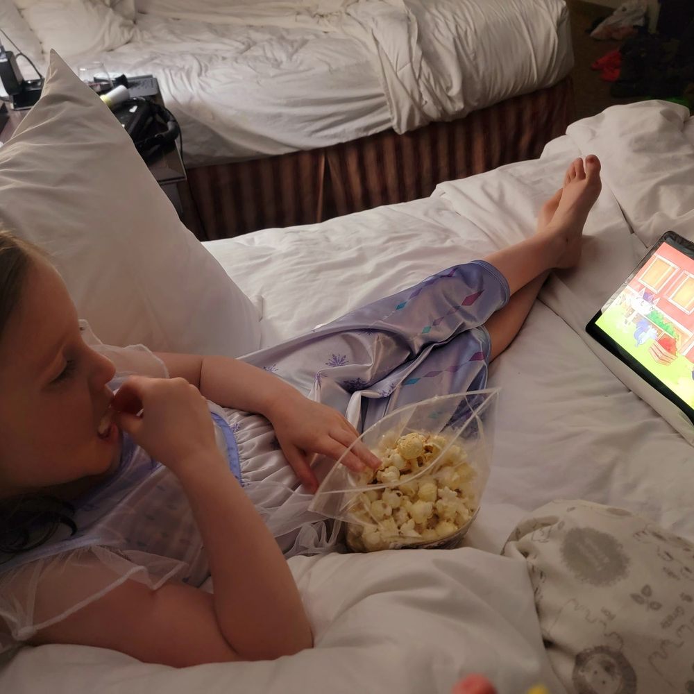 My daughter watching a show and eating the really delicious popcorn they sell in the lobby.