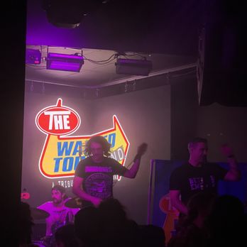 Ember Music Hall - a man on stage in front of a neon sign - Music Venues Near Me - Richmond, Virginia