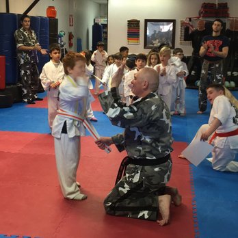Power MMA Krav Maga - Receiving an orange stripe belt and a high five from Sensei Yuri. - Martial Arts Near Me - Pomona, New York Power MMA Krav Maga - Receiving an orange stripe belt and a high five from Sensei Yuri. - Martial Arts Near Me - Pomona, New York