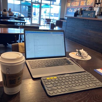 Starbucks - a laptop and a cup of coffee on a table - Coffee & Tea Near Me - D'Iberville, Mississippi