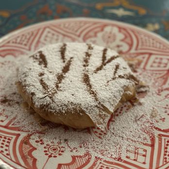 Le Bazaar - a pastry on a plate with powdered sugar - Moroccan Near Me - Kihei, Hawaii Le Bazaar - a pastry on a plate with powdered sugar - Moroccan Near Me - Kihei, Hawaii