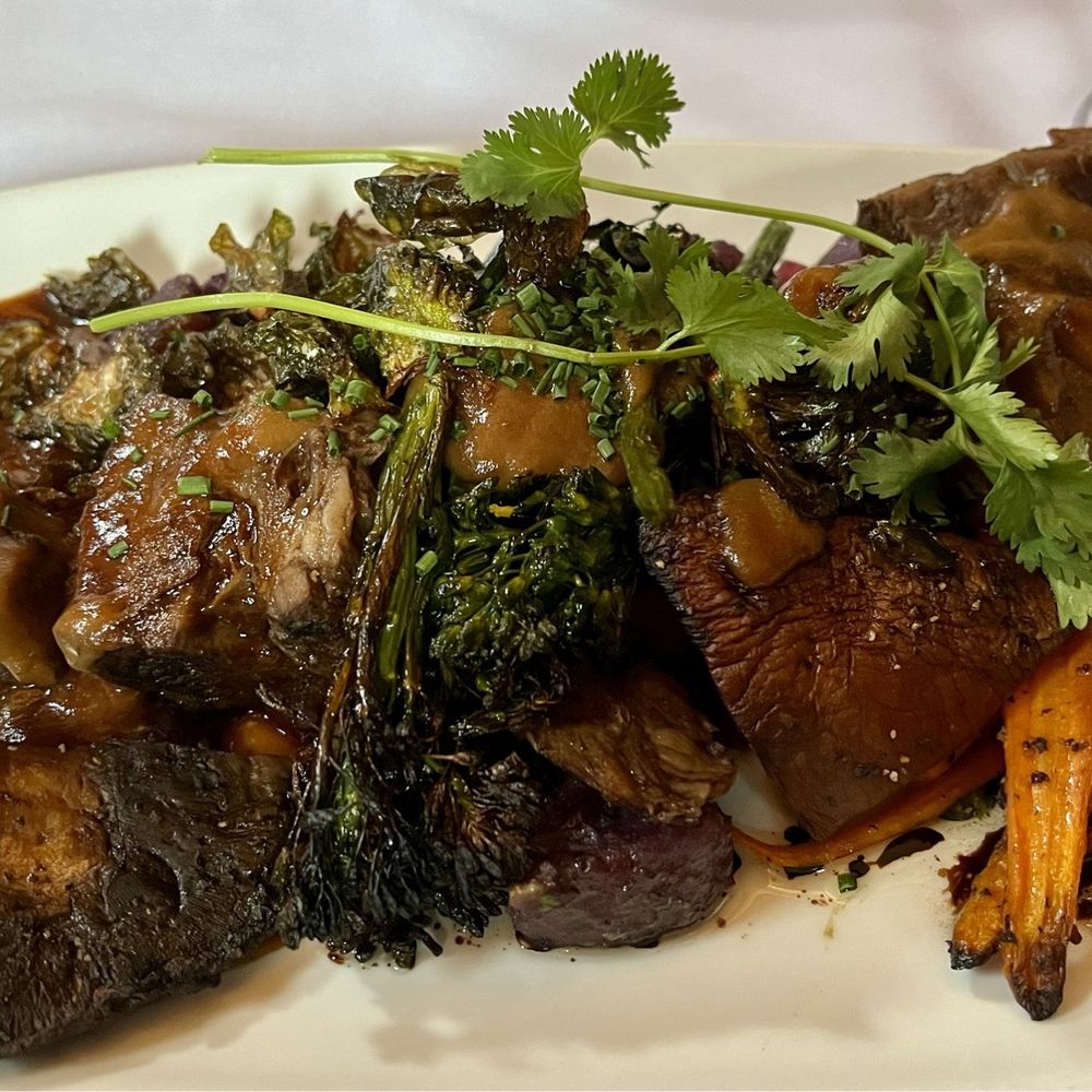Orchard Green - Roasted bison with portobello mushroom, broccolini, carrots & purple potatoes in gravy sauce - New American Near Me - Iowa City, Iowa Orchard Green - Roasted bison with portobello mushroom, broccolini, carrots & purple potatoes in gravy sauce - New American Near Me - Iowa City, Iowa
