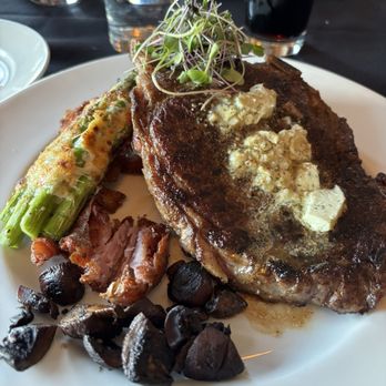 Benaiahs Scratch Kitchen - 16oz Ribeye garnished with a compound butter, crispy fingerling potatoes and cremini mushrooms. The asparagus parmigiana is to die for! - Cocktail Bars Near Me - Harrisburg, Pennsylvania