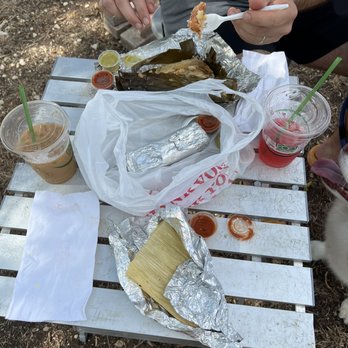 Tamale Addiction - a man and a dog eating food - Farmers Market Near Me