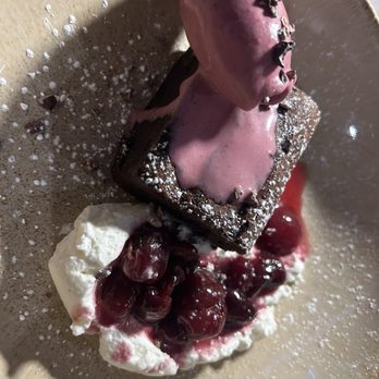 Alsace - Deconstructed Black Forest with homemade cherry ice cream. - A dessert featuring a pink ice cream with chocolate shavings on top, served on a square brownie with cherry compote and whipped cream. - French Near Me - Union, Maine