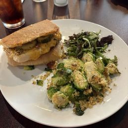 Ham and cheese panini with house made pickles and Brussels sprouts. Ham and cheese panini with house made pickles and Brussels sprouts.