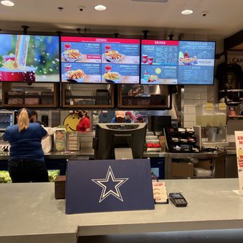 Raising Cane's Chicken Fingers - a restaurant counter with a large television screen - Chicken Wings Near Me - Laredo, Texas Raising Cane's Chicken Fingers - a restaurant counter with a large television screen - Chicken Wings Near Me - Laredo, Texas