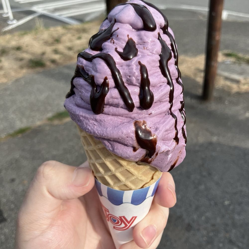 Sweet cream base with blackberry and chocolate sauce, in a waffle cone